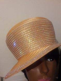 "Deep yellow mango gold satin ribbon year round high crown hat with side fancy hat. Multiple rows of AB rhinestone on clear trim covers majority of the crown, and triple rows of trim around the brim edge.  This uniquely designed brim can be worn to the right or more to the front for a captain style hat.  The center of the crown can be worn pushed up as a dome or pushed down to give it a saucer effect.  The crown height is 6\", 8 1/2 \" in width, the base of the hat is 11\" across. The brim measures 1\" in the back and left side, 2\" in front. The right side has a dramatic 3\" width.  There is a  drawstring in the band that  makes for easy sizing.  All work has been done in a smoke-free environment. This hat is finished and ready for next business day shipping at no additional charge.  \"Yo Yellow Mango, Church Hat, Deep Yellow, Crown Hat, Crown Heights, Elegant Hats, Fancy Hats, Church Hats, Gold Satin