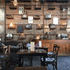 the interior of a restaurant with brick walls and wooden tables, chairs, and pictures on the wall