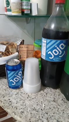 the counter top is covered with condiments and bottled beverages, along with other food items