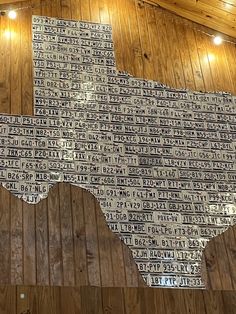 a map made out of license plates on a wall in a building with wood paneling