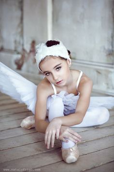 a young ballerina is posing for the camera