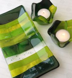 two green and yellow glass dishes with candles