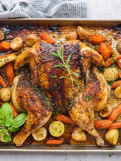 roasted chicken with carrots and potatoes on a baking sheet