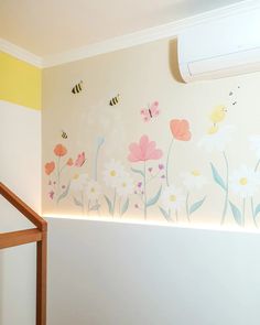 a wall with flowers and bees painted on it in a child's playroom