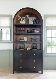 a black china cabinet with gold handles and knobs