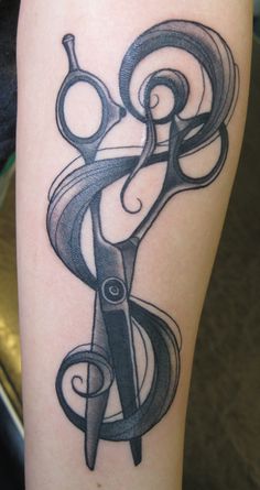 a tattoo with scissors and swirls on it