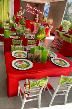 a table set up for christmas with green and red decorations on the table cloths