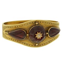 An absolutely exquisite garnet and diamond bangle bracelet from the Victorian (ca1880) era! This wide bangle is made of vibrant 15kt yellow gold and has a fantastic 3-dimensional design on the front surface. At the center of the bracelet is a round cabochon garnet stone which has a hand carved scalloped surface. Set in the center is a gold starburst that is accented with 8 old Rose Cut and an old Mine Cut. Set on each side of the center stone are 2 additional garnet stones that are tear drop sha Cabachon Jewelry, Diamond Gold Bracelet, Diamond Bangle Bracelet, Gold Starburst, Yellow Gold Bangle, Freshwater Pearl Jewelry, Beautiful Bracelets, Bronze Necklace, Gold Armband