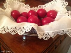 a bowl filled with red tomatoes on top of a wooden table