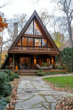 a - frame cabin with stone walkway leading up to the front door and covered porch