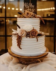 a white wedding cake with flowers on top