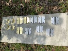 several pieces of metal sitting on top of a cement slab in the middle of grass