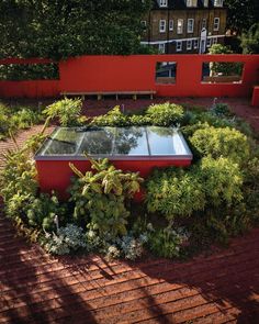 a red building surrounded by plants and trees