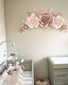 a baby's room with a crib and flowers on the wall