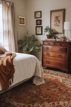 a bed sitting next to a window in a bedroom on top of a wooden dresser