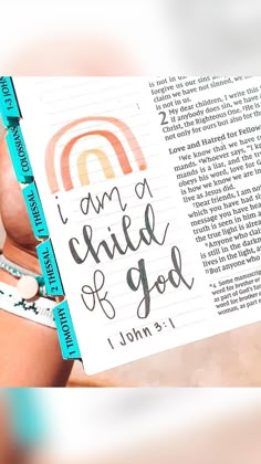 a woman holding up a book with the words i am a child of god written on it