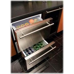 an open refrigerator with drinks in it sitting on the floor next to a counter top