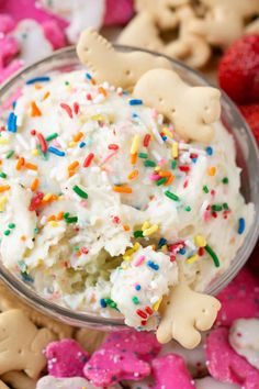 a person is holding up a small cup filled with ice cream and sprinkles