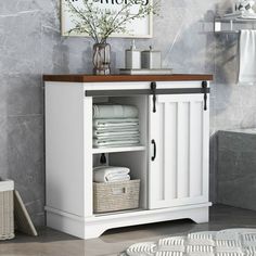 a white cabinet with baskets and towels in it