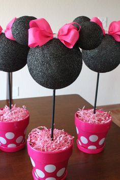 a minnie mouse centerpiece with pink bows on it's head in a cup