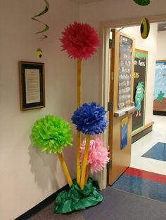 colorful paper pom poms are on display in the hallway