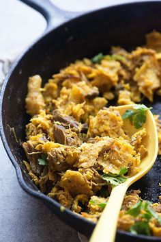 a skillet filled with food and a wooden spoon