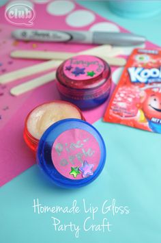 two small containers with toothbrushes and some candy on a pink table cloth next to them