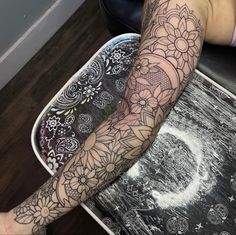 a person sitting on top of a table with a tattoo on their arm and leg