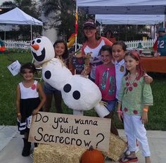 a group of children standing next to a sign that says do you wanna to build a scarecrow?