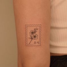 a postage stamp with a flower on the left side of the arm and an arrow in the middle