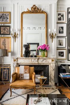 a living room filled with furniture and a fire place under a mirror on the wall