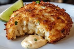 a close up of food on a plate with a lime wedge and sauce in the background