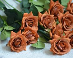 there are many orange roses on the table