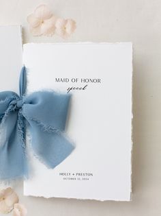 a blue ribbon tied to the front of a wedding card