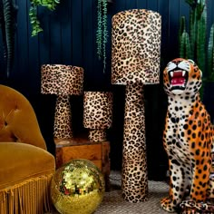 a leopard statue sitting next to some decorative items and a chair with its mouth open