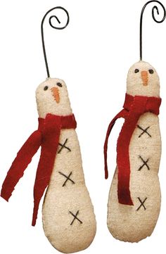 two snowmen with red scarves on their heads are hanging from black metal hooks