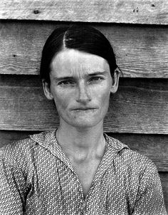 an old black and white photo of a woman in front of a wooden wall with her eyes closed