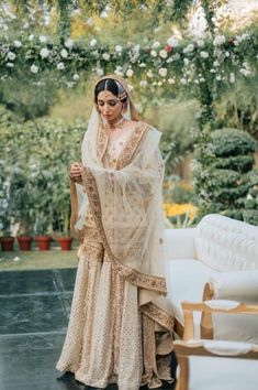 a woman in a wedding dress standing near a couch