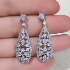 This delicate pair of earrings is adorned by flawlessly faceted cubic zirconia that capture the light from every angle with a perfectly translucent appeal, sparkling beautifully. Rhodium plated for a flawless finish which enhances the intricate detailing and conveys a modern take on old elegance, this exquisite design will add a touch of sophistication to any wedding gown or formal ensemble. Overall length of the earring is 40mm (approx. 1.5") and measures 12mm (approx. 1/2") wide. Hypoallergeni Fine Jewelry Sparkling Cubic Zirconia Earrings, Sparkling Cubic Zirconia Fine Jewelry Earrings, Sparkling Cubic Zirconia Diamond Earrings Fine Jewelry, Sparkling Cubic Zirconia Diamond Earrings, Exquisite Cubic Zirconia Teardrop Chandelier Earrings, Dazzling Diamond White Crystal Earrings With Sparkling Stones, Exquisite Teardrop Chandelier Earrings In Cubic Zirconia, Dazzling Diamond White Crystal Earrings, Dazzling Diamond White Crystal Earrings With Brilliant Cut