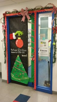 an office decorated for christmas with a tree and grino's hat on the door