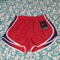 Reddish Orange With Purple And White Striped Detail On Sides, Adjustable Draw Strings, Lined, Elastic Waist , New With Tags! Nike Red Sporty Shorts, Nike Red Sporty Athletic Shorts, Nike Sporty Red Athletic Shorts, Nike Red Athletic Shorts, Red Stretch Nike Athletic Shorts, Nike Red Stretch Athletic Shorts, Red Nike Workout Bottoms, Nike Red Workout Shorts, Nike Athletic Shorts