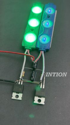 an electronic device with two green lights attached to the back of it and wires connected to each other