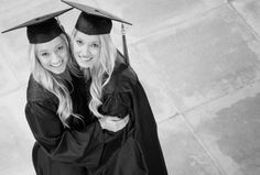 two women in graduation gowns hugging each other