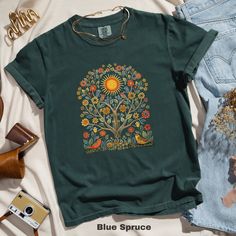 🌞 Embrace the beauty of nature with this Scandinavian Folk Art T-Shirt featuring vibrant sunshine, birds, and colorful floral patterns. Perfect for adding a touch of whimsical charm to your wardrobe! 🌸🕊️  Comfort Colors 1717 is a fully customizable tee made 100% with ring-spun cotton. The soft-washed, garment-dyed fabric brings extra coziness to your wardrobe while the relaxed fit makes it an excellent daily choice. The double-needle stitching throughout the tee makes it highly durable while Summer Cotton Tops With Bird Print, Nature-inspired T-shirt With Plants Print For Summer, Summer Crew Neck T-shirt With Bird Print, Green Cotton Nature-inspired T-shirt, Spring Nature-inspired Tops With Graphic Print, Nature-inspired Green Cotton T-shirt, Green Nature-inspired Cotton T-shirt, Nature-inspired Summer T-shirt With Plant Print, Nature-inspired Graphic Print T-shirt For Spring