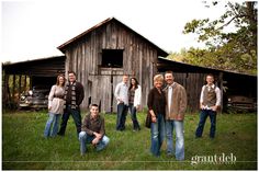 a group of people standing in front of a barn