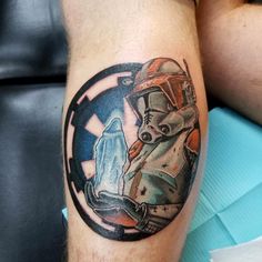 a tattoo on the leg of a man with a baby yoda in a star wars helmet