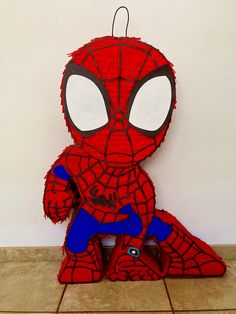 a paper cut out of spiderman sitting on the floor