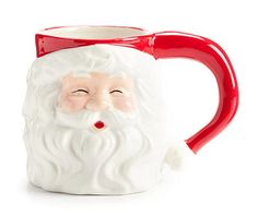 a red and white mug with a santa clause on it's face, sitting in front of a white background