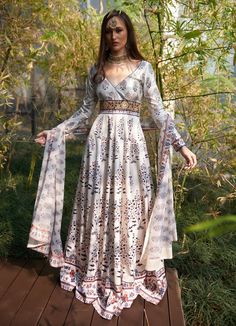 This elegant White Printed Satin Silk Anarkali Gown, crafted from luxurious satin silk, exudes graceful charm with its flowing design and intricate details. The white anarkali showcases mesmerizing printed motifs inspired by traditional patterns, accentuated by delicate waist embroidery for a touch of regal opulence. Featuring a flattering V-neckline and full-length sleeves, the Anarkali flows effortlessly, creating captivating movement with every step. Paired with a comfortable matching churida Traditional Off White Gown For Designer Wear, Festive Anarkali Gown In Off White, Traditional Off White Designer Gown, Off White Anarkali Floor-length Gown, Traditional Off-white Gown For Designer Wear, Traditional Off-white Designer Gown, Off White Floor-length Anarkali Gown, Off White Anarkali Gown With Dupatta, White Anarkali Floor-length Dress