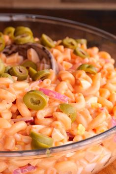 a bowl filled with macaroni salad on top of a wooden table